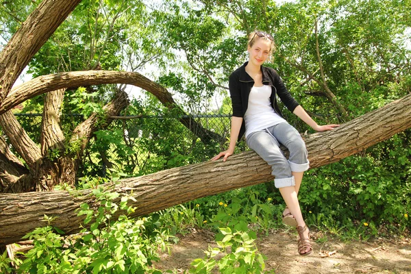 Adolescente sentarse en una rama — Foto de Stock