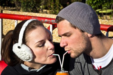 Couple Drinking A Juice Out Of A Can With Two Straws clipart