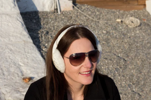 Donna con orecchio bianco manicotti e occhiali da sole — Foto Stock