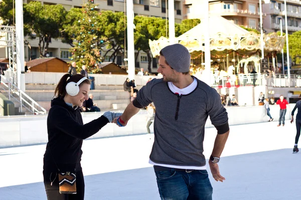 Молодая пара катается на коньках вместе и веселится — стоковое фото