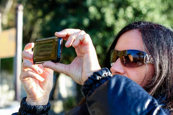 携帯電話で写真を撮影暗い髪の女性 — ストック写真