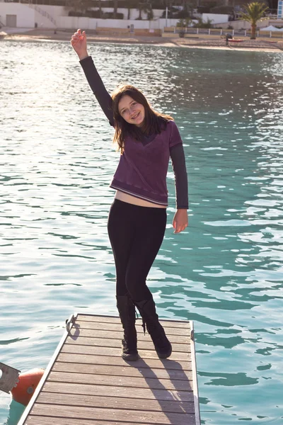 Gelukkig meisje permanent op een pier — Stockfoto