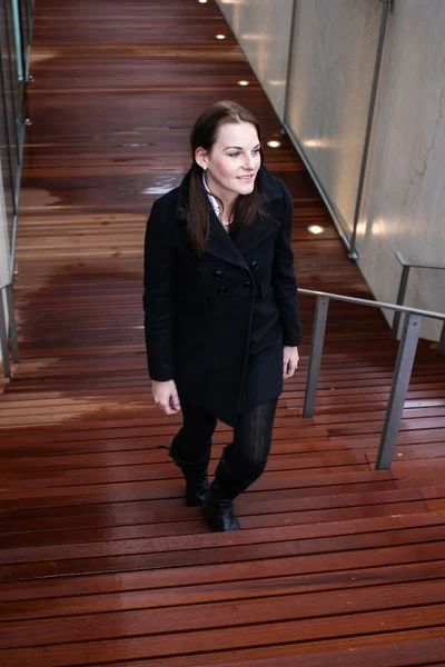 Brunett kvinna gå uppför trappor — Stockfoto