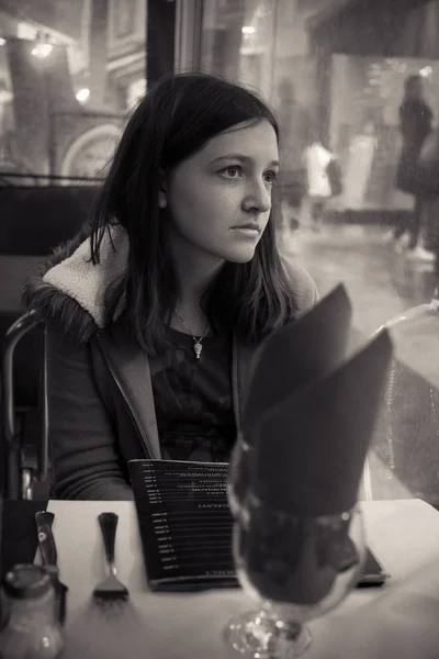 Jonge brunette meisje, zittend in een restaurant — Stockfoto