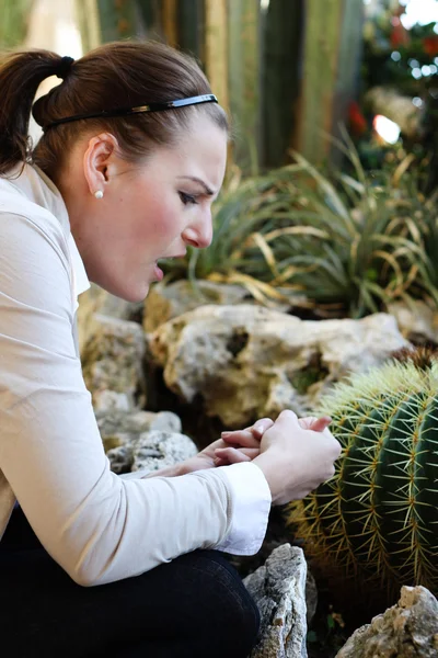 stock image Woman pricked herself on a thorn from a cactus