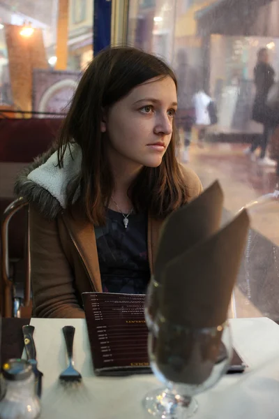 Młoda brunetka dziewczyna siedzi w restauracji — Zdjęcie stockowe