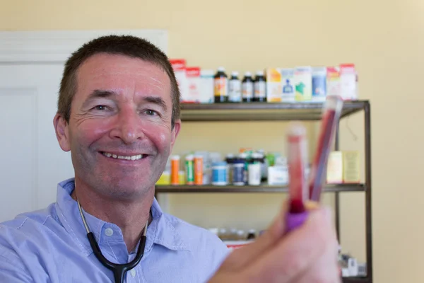 Mature Doctor Showing Blood Capsules — Stock Photo, Image