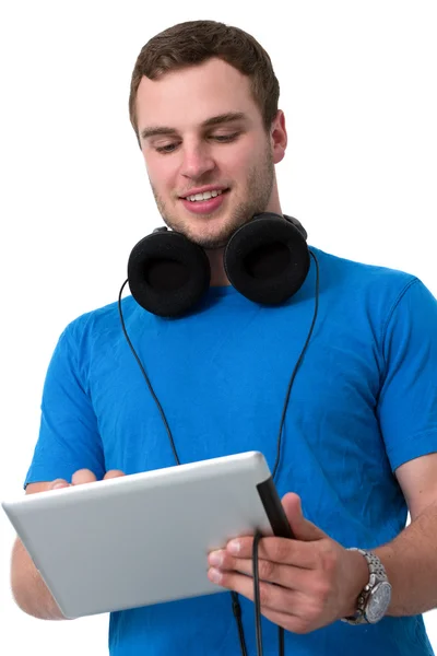 Młody człowiek z słuchawkami działa na komputerze typu tablet — Zdjęcie stockowe