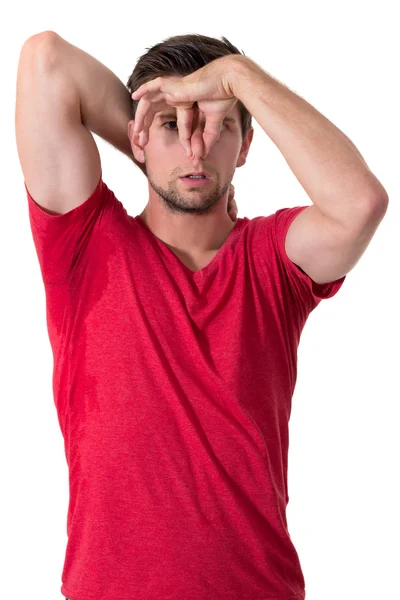 Man sweating very badly under armpit and holding nose — Stockfoto