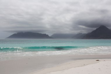 Beach of Kommetjie with an upcoming storm in the background clipart