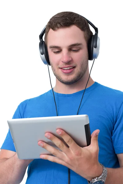 Νεαρός άνδρας με ακουστικά που εργάζονται σε ένα tablet pc — Φωτογραφία Αρχείου