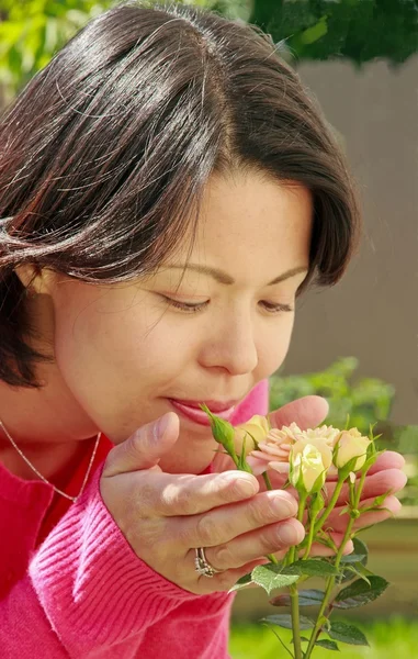 Женщина пахнет розами — стоковое фото