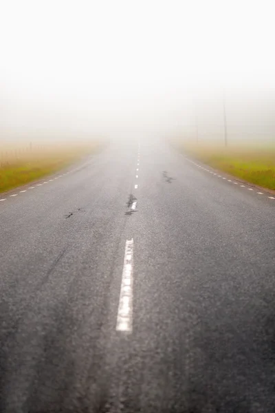 Асфальтовая дорога в тумане — стоковое фото