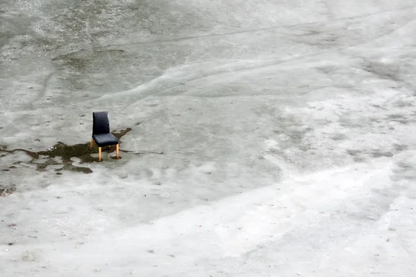 Chaise noire sur glace fondante — Photo