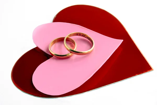 Gold wedding rings and red hearts — Stock Photo, Image