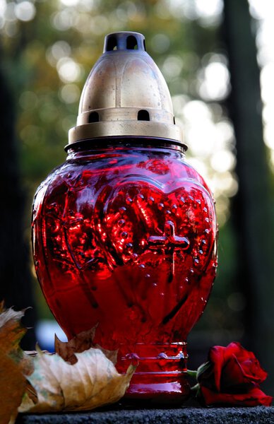 Red everlighting candel on tomb in cemetery