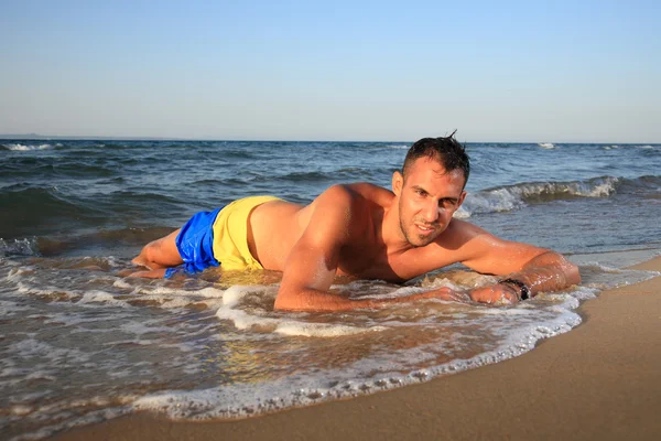 Mladý muž relaxující na pláži — Stock fotografie