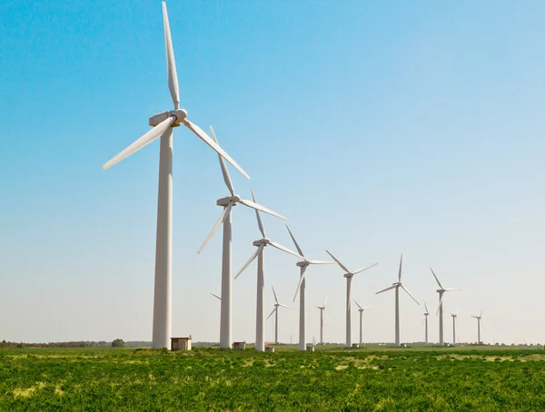 Зеленый луг с ветряными турбинами, генерирующими электричество — стоковое фото