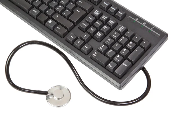 Um estetoscópio é conectado ao teclado. sobre um background branco — Fotografia de Stock