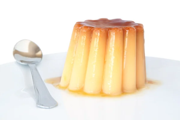 Pudding mit Karamell auf einem Teller auf weißem Hintergrund. — Stockfoto