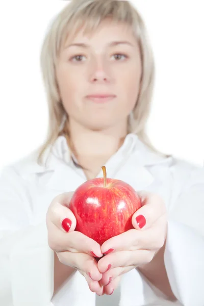 La chica enfermera sostiene una manzana — Foto de Stock