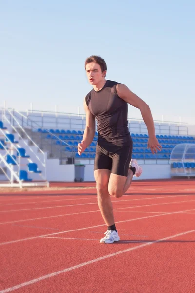 A young man starts running in the stadium. Treadmill. — Stock Photo, Image