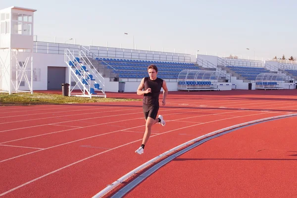 Mladý muž, běh, jogging na stadionu. — Stock fotografie