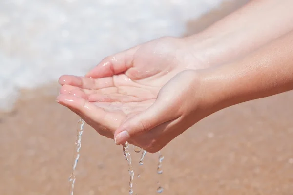 Ręce w wodzie na plaży. — Zdjęcie stockowe