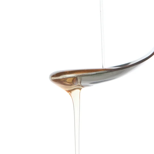 Aceite de oliva se vierte sobre una cucharadita. —  Fotos de Stock