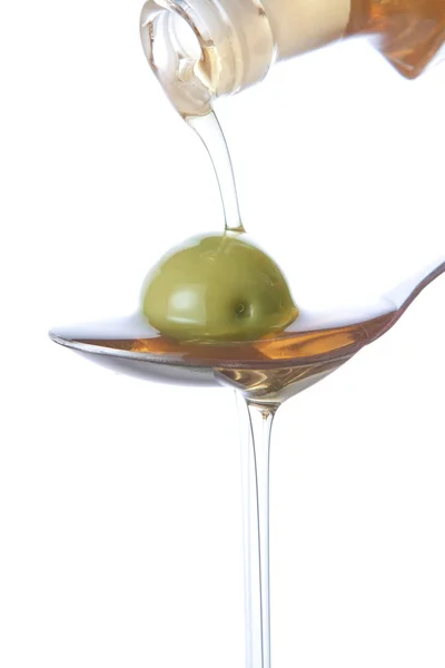 Gießen von Olivenöl aus einer Flasche. — Stockfoto