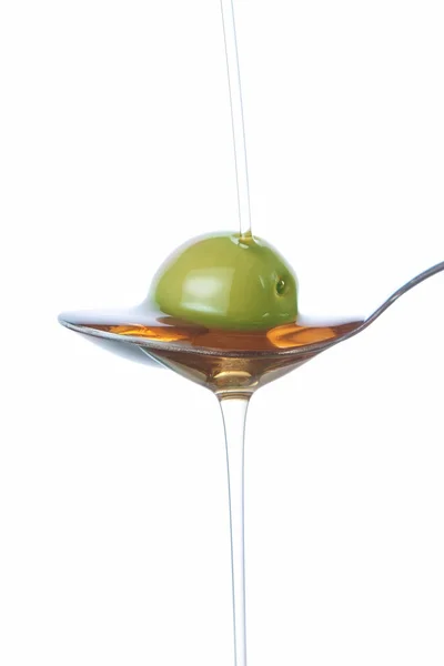 Olive on the spoon, pouring with oil. — Stock Photo, Image