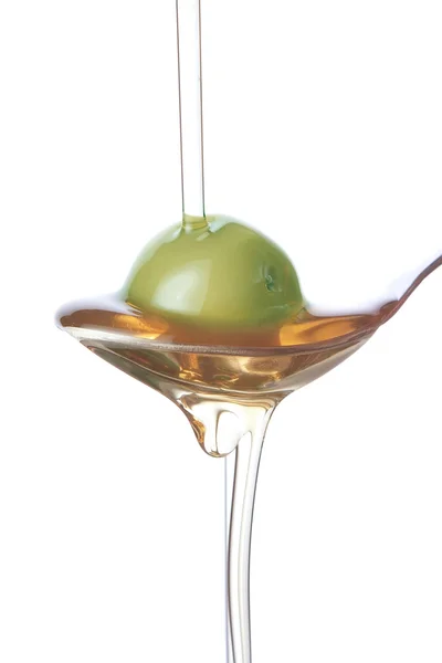 Olive sur une cuillère, pulvérisation avec de l'huile. — Photo