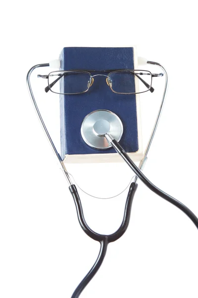 O estetoscópio do médico de livro e óculos. sobre um fundo branco. — Fotografia de Stock