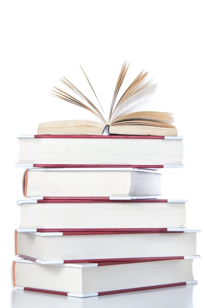 Abra el libro sobre la pila de libros. sobre un fondo blanco. — Foto de Stock