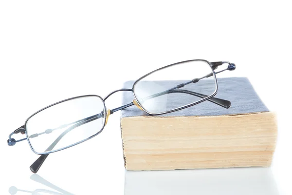 Le livre est un dictionnaire et lunettes sur fond blanc. — Photo