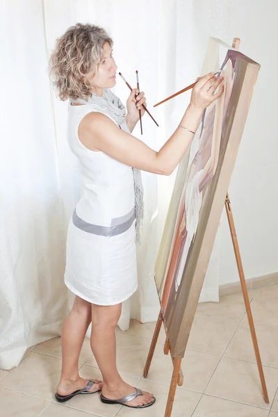 Malíř kreslí obrázek na stojanu. — Stock fotografie