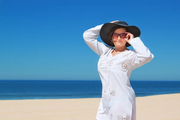 Mooi meisje in de hoed op het strand. — Stockfoto