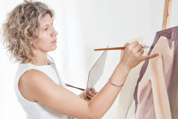 Målare målar en bild med penslar. — Stockfoto