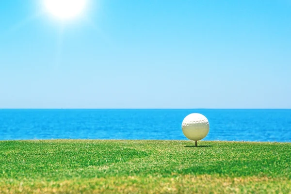 Мяч для гольфа на стенде на фоне океана. Португалия. — стоковое фото