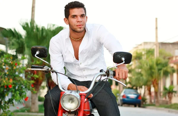 Schöner junger Mann sitzt auf altem Motorrad — Stockfoto