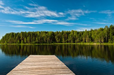 Wooden pier on lake scene clipart