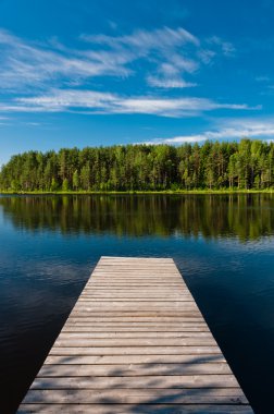 Wooden pier on lake symmetrical scene clipart