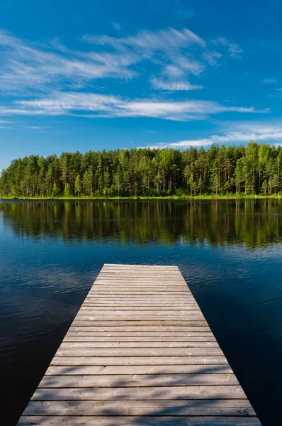 stock image Wooden pier on lake symmetrical scene