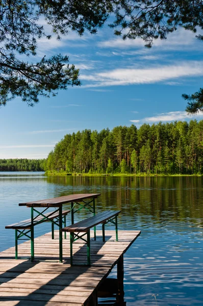 stock image Wooden pier on lake with benches