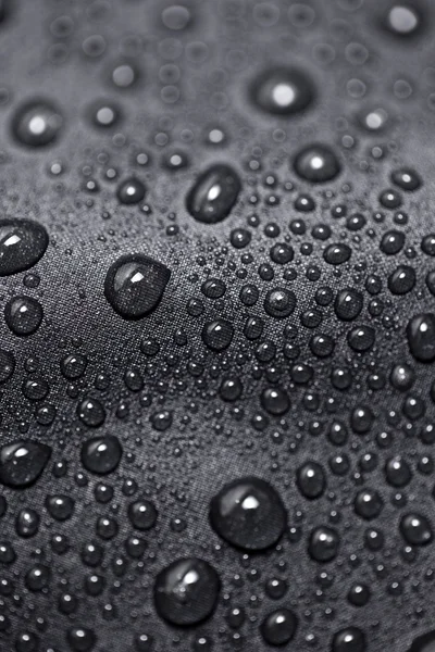 Ефект лотоса з краплями води на чорному текстилі — стокове фото