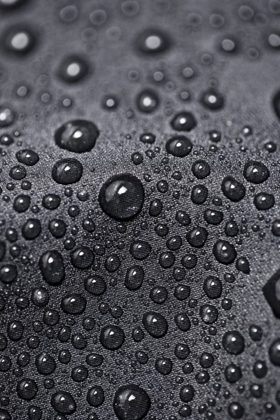 Lotus efekt s vodou kapky na černé textilní — Stock fotografie