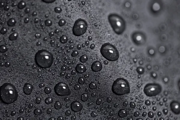 Lotus-effect met water druppels op zwarte textiel — Stockfoto