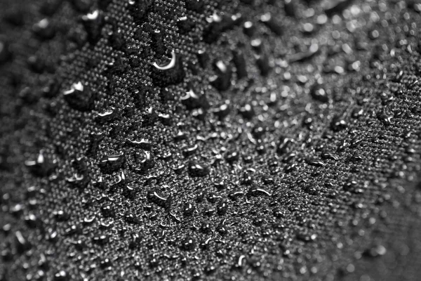 Efeito de lótus com gotas de água em têxteis pretos — Fotografia de Stock