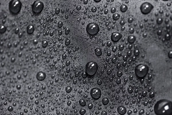 Lotus-effect met water druppels op zwarte textiel — Stockfoto