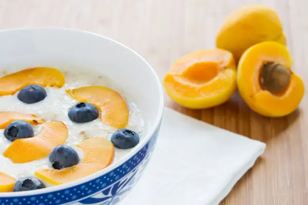 Oatmeal porridge with fresh berries and apricots — Stock Photo, Image